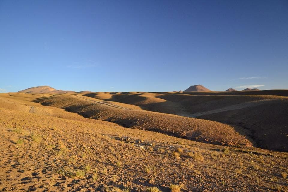 Layered desert terrain and mountains in the Atacama region.
