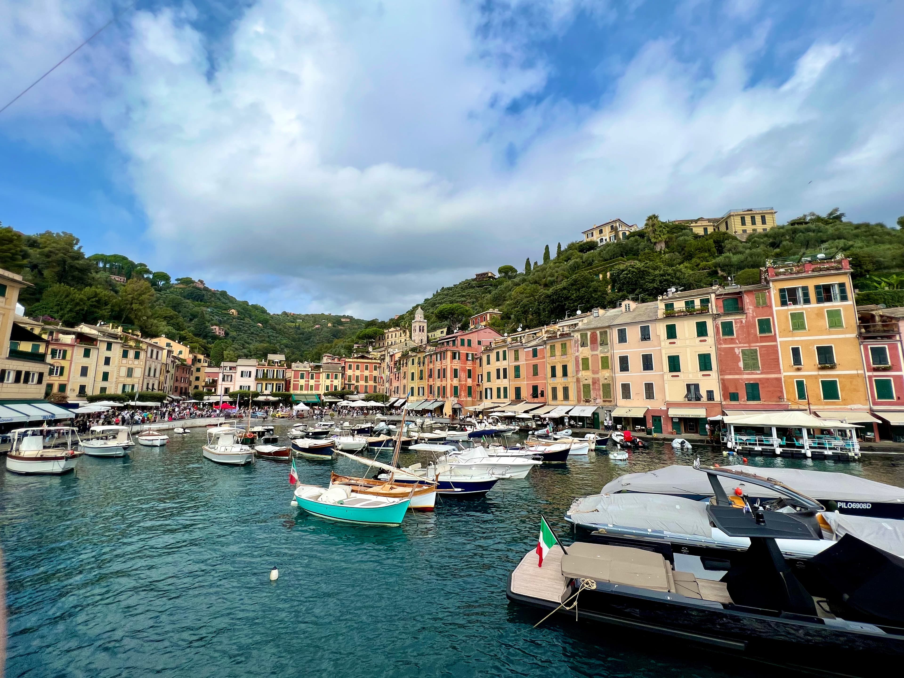 A coastal Italian town with colorful buildings and a clock tower.